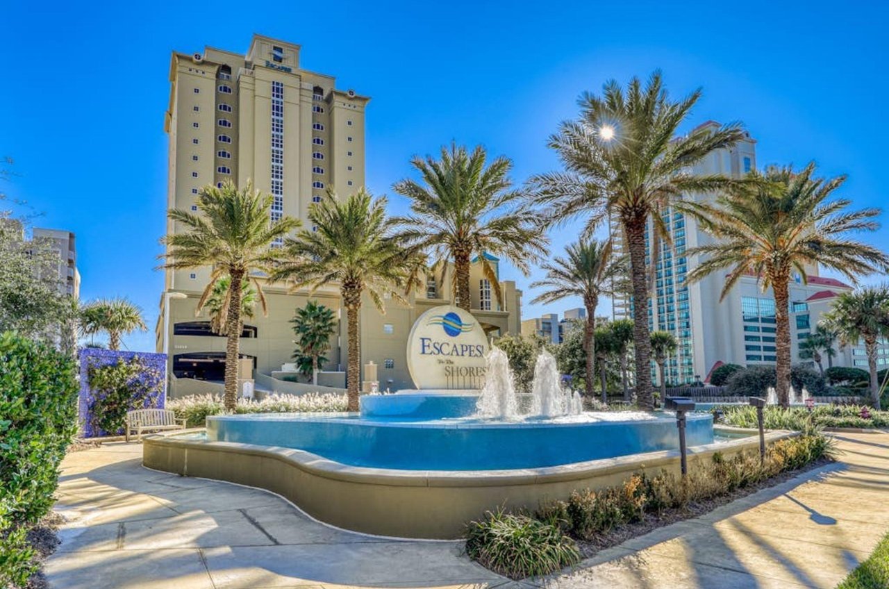 The waterfountain and palm trees in front of Escapes to the Shores in Orange Beach Alabama