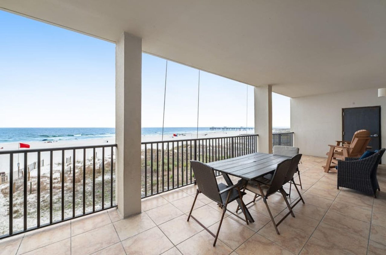 A private balcony with chairs and tables overlooking the Gulf at the Palms in Orange Beach Alabama