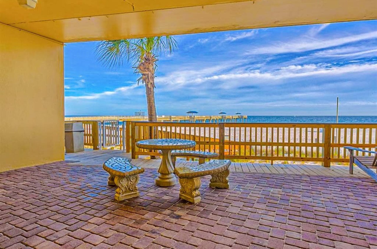 A covered stone picnic table overlooking the beach at Emerald Skye