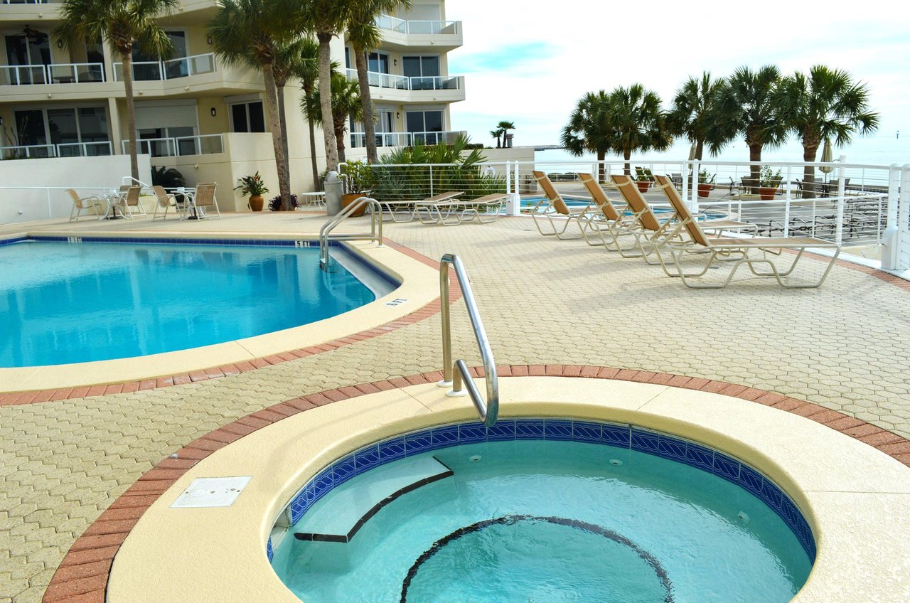 The swimming pools, hot tub and sundeck sit beside Gulf waters.