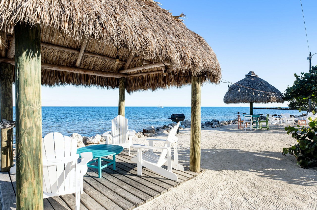 This waterfront hut is furnished with adirondack chairs around a coffee table and perfect for peaceful relaxation.