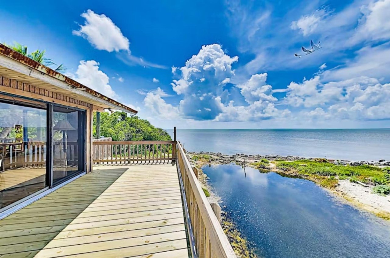A Key Largo  vacation homes spacious deck looks out over the Gulf while three egrets fly overhead.