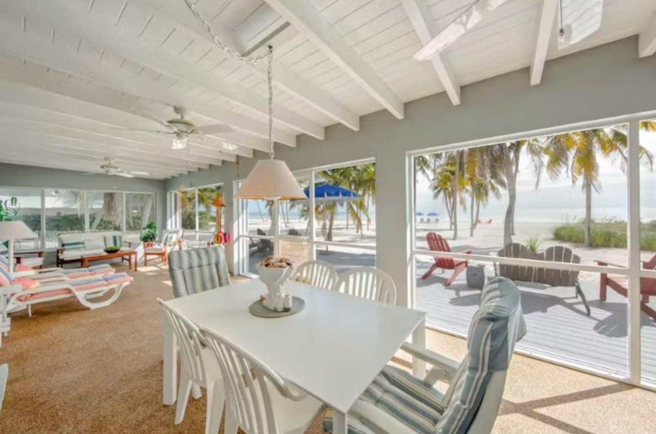 This Islamorada vacation home has a spacious sunroom leading to an expansive deck looking out over a beautiful beach.