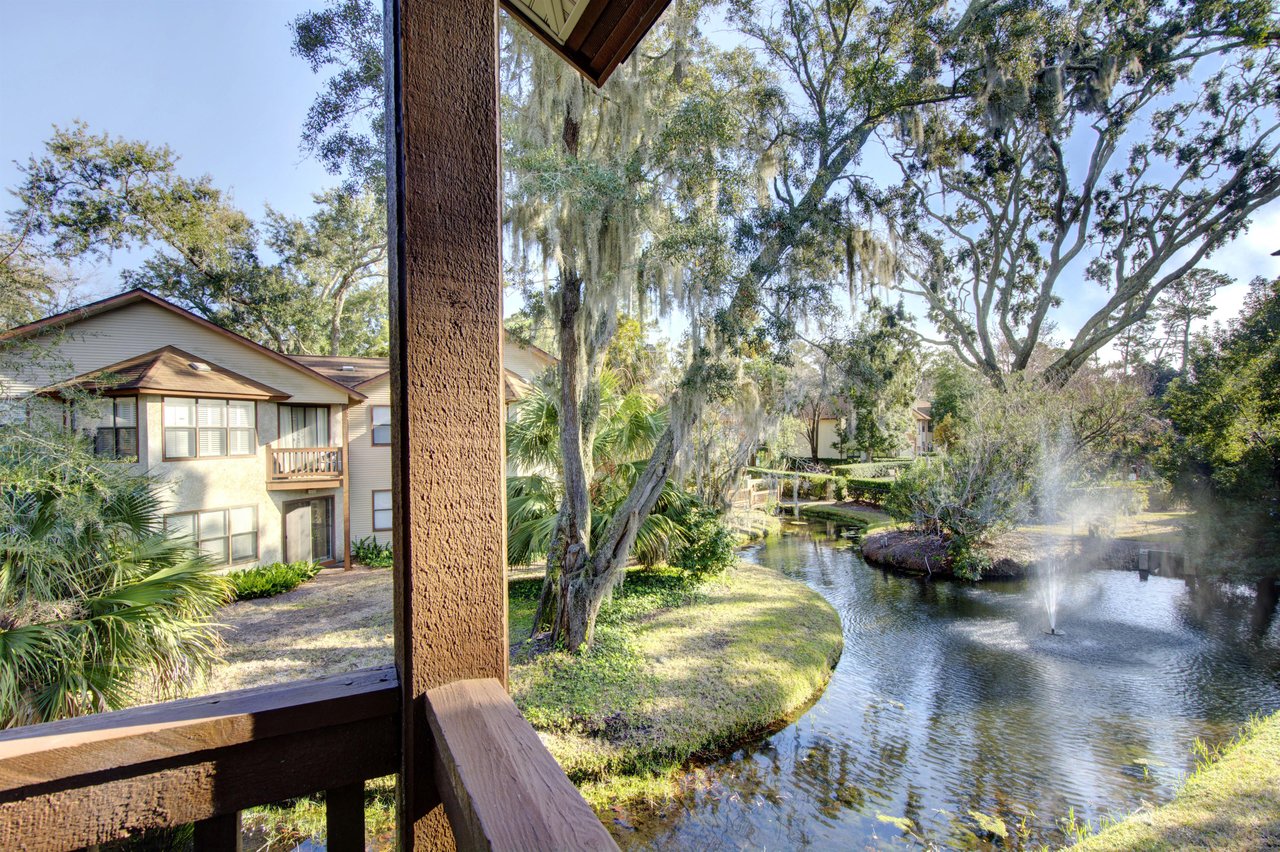 Take in the peaceful view of fountains and mossdraped oaks from the balcony at 406 Harbour Oaks, where lush landscaping winds through the quiet gated community.
