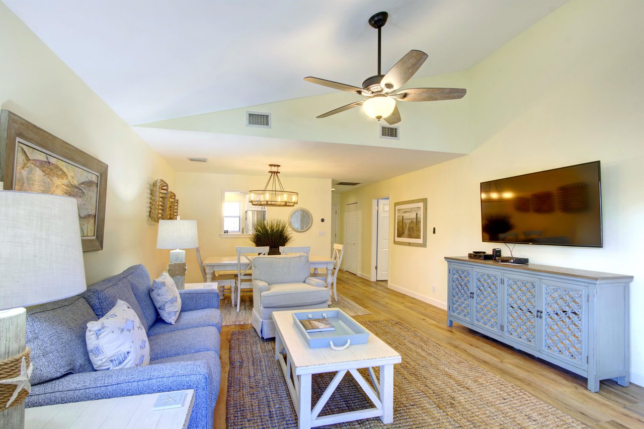Enjoy movie nights or a quiet afternoon in the openplan living space at 406 Harbour Oaks, featuring a large smart TV and easy flow into the dining area.