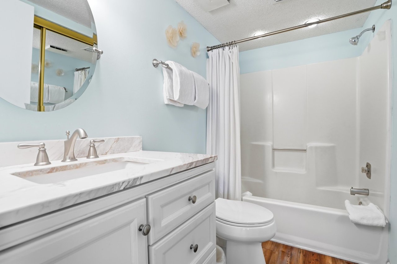 Marblestyle vanity and updated fixtures complement a clean, welldesigned space off the primary bedroom.