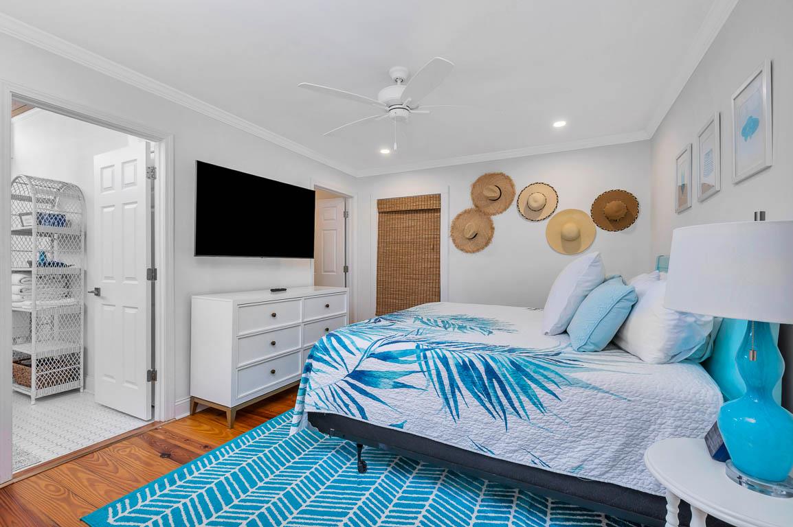 Primary bedroom at 530 Delegal showing a king bed, wallmounted television, and an open view into the en suite bathroom with tiled shower.