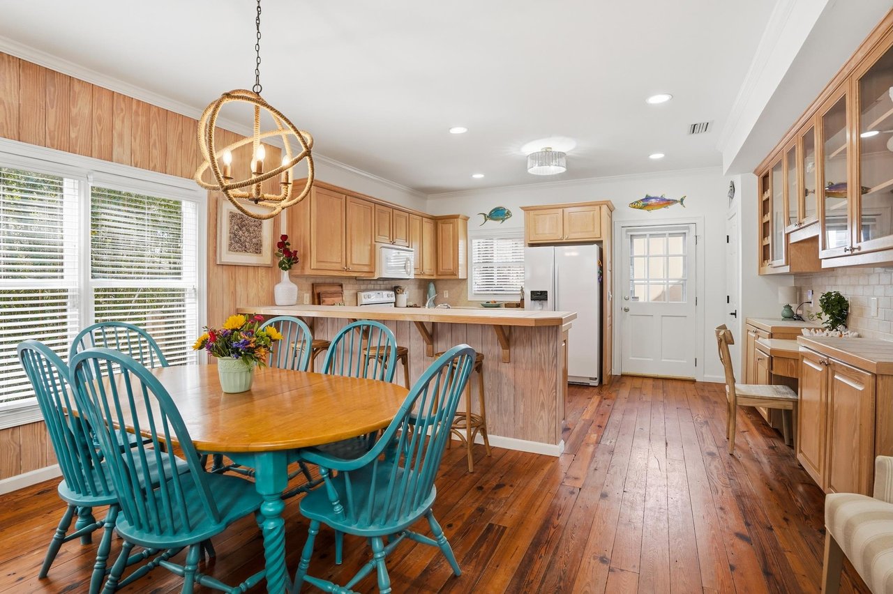 Open kitchen with natural wood cabinetry, wraparound counters, breakfast bar, and an easy connection to the dining area.