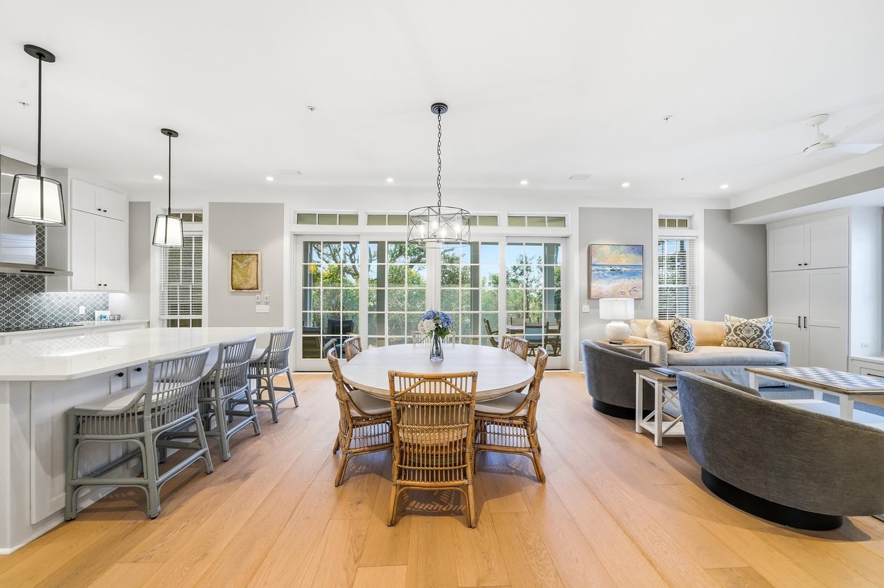 The main gathering space keeps nine guests connected with porch access, abundant windows and a generous kitchen island.