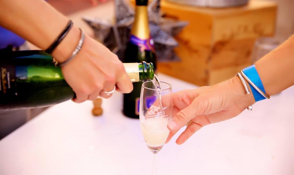 a woman pouring a glass of sparkling wine of 1