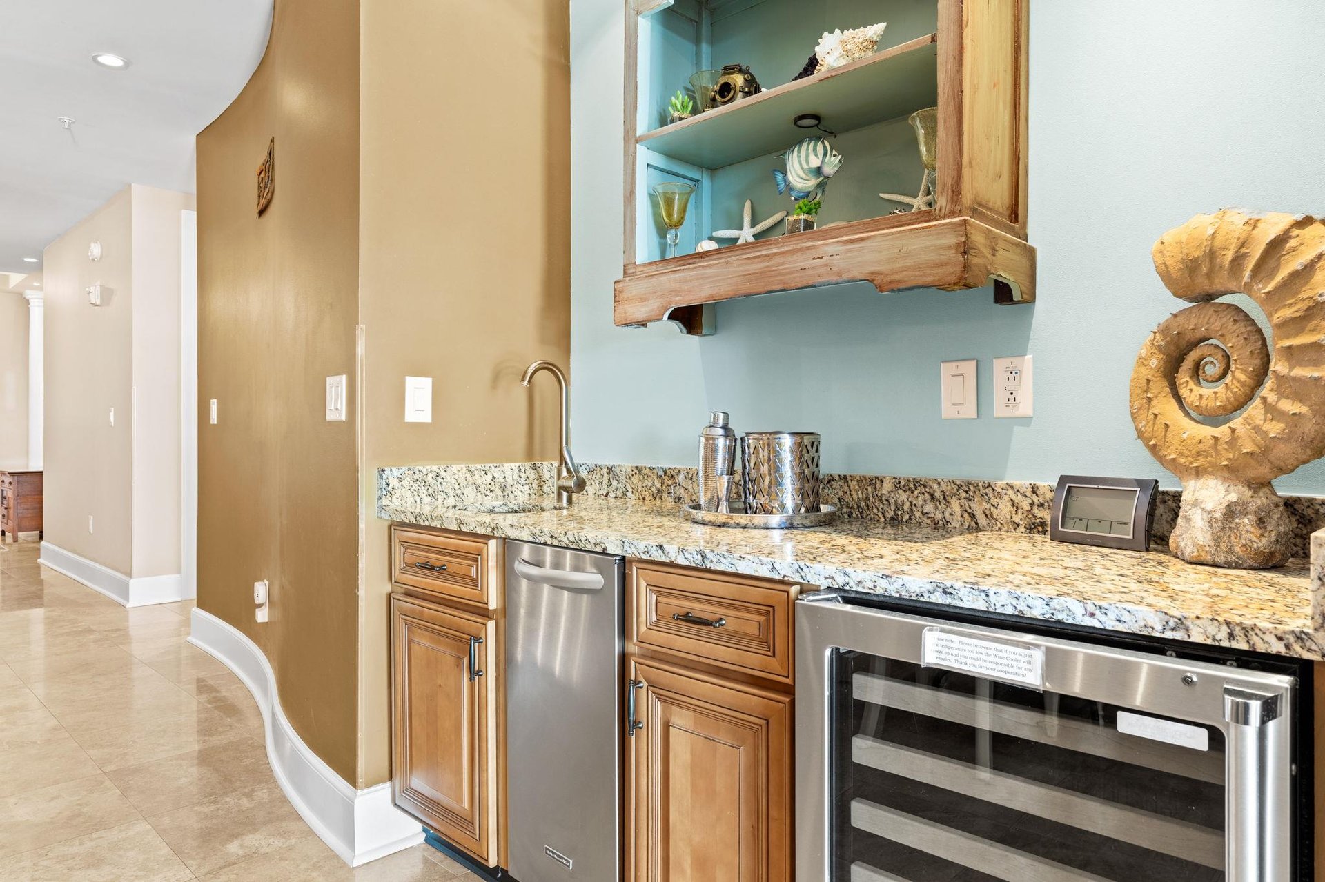 Your stylish wet bar features granite counters, stainless appliances, and coastalinspired shelving perfect for entertaining.