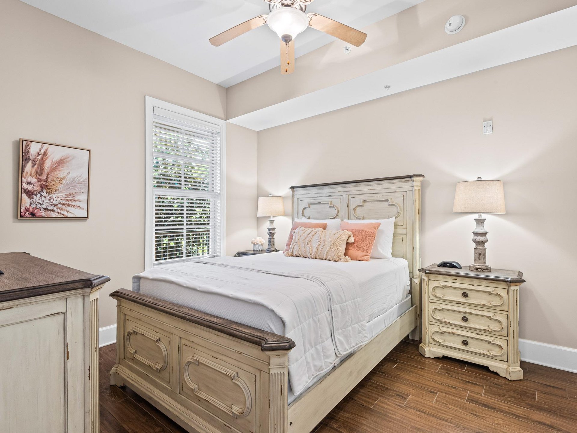 Drift off to peaceful sleep in your elegant bedroom featuring soft coral accents beneath the gentle breeze of your ceiling fan.