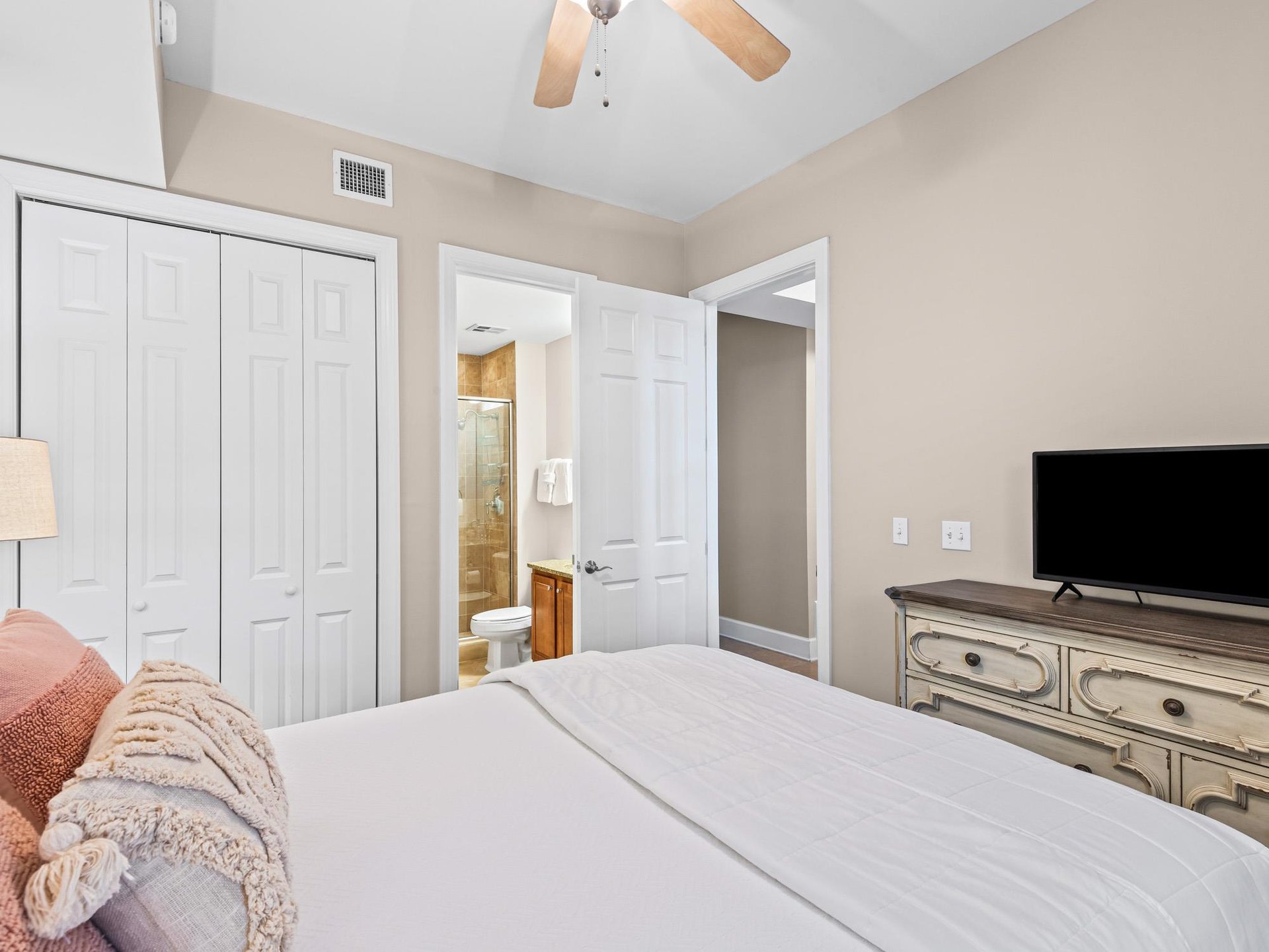 Unwind in your serene bedroom featuring a plush Queen bed, ceiling fan for comfort, and convenient ensuite bathroom access.