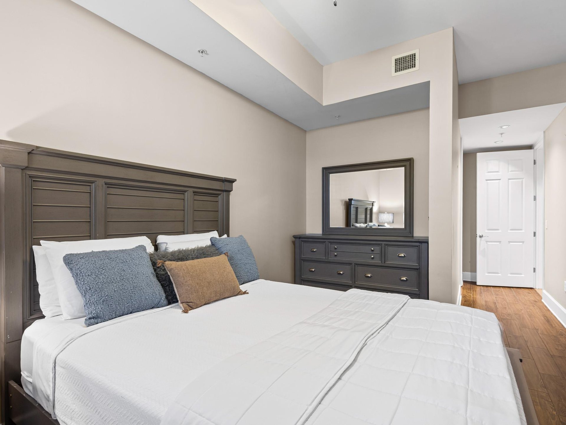 Bedroom 3 Sink into the comfy Queen bed and plush pillows in your elegant bedroom, featuring warm wood floors and stylish furnishings for ultimate comfort.