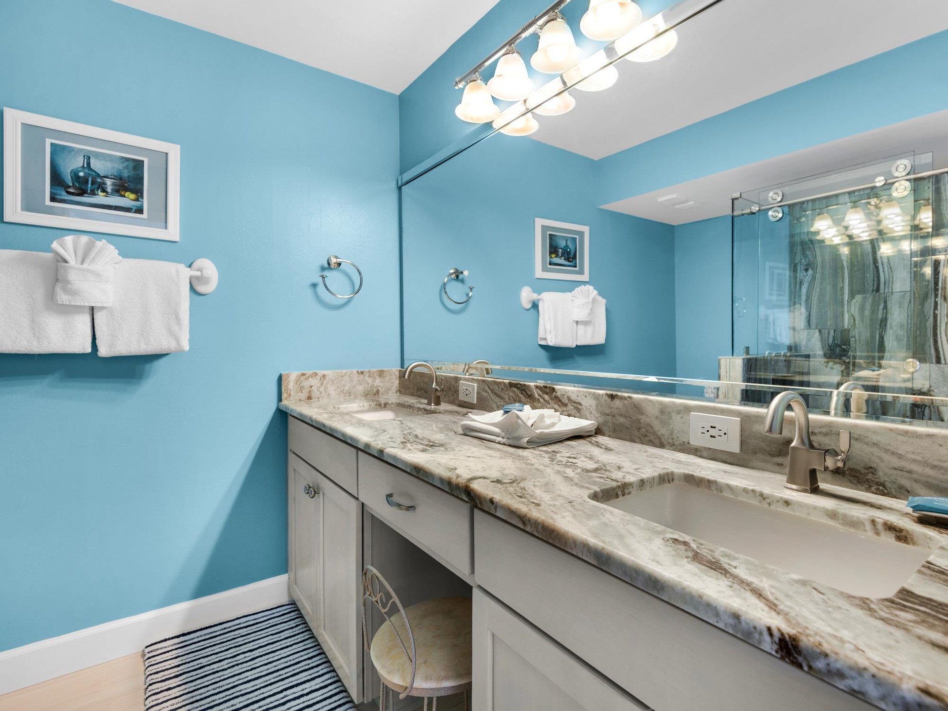 Refresh in your elegant bathroom with marble countertops, dual sinks, and cheerful blue walls that brighten every morning routine.