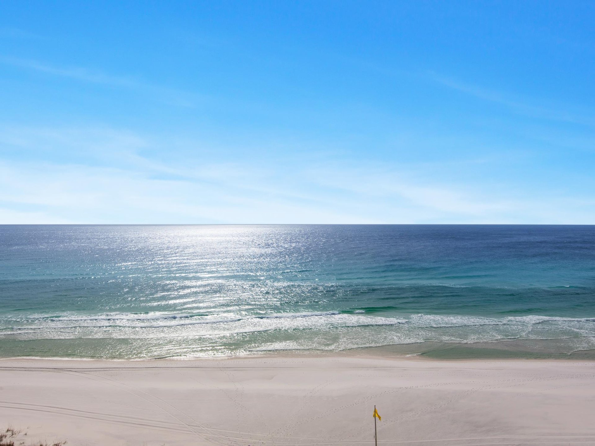Pristine beach with crystalclear turquoise waters and soft white sand stretches endlessly under brilliant blue skies.
