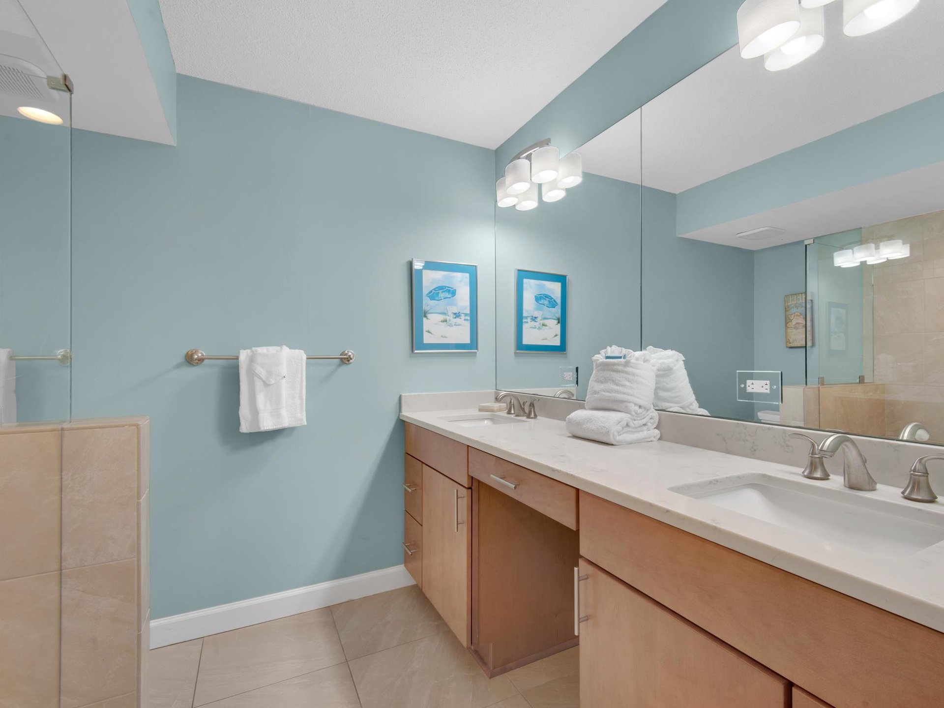 Refresh in your spacious bathroom featuring dual vanities, plush towels, and soothing coastal colors that create a spalike retreat.