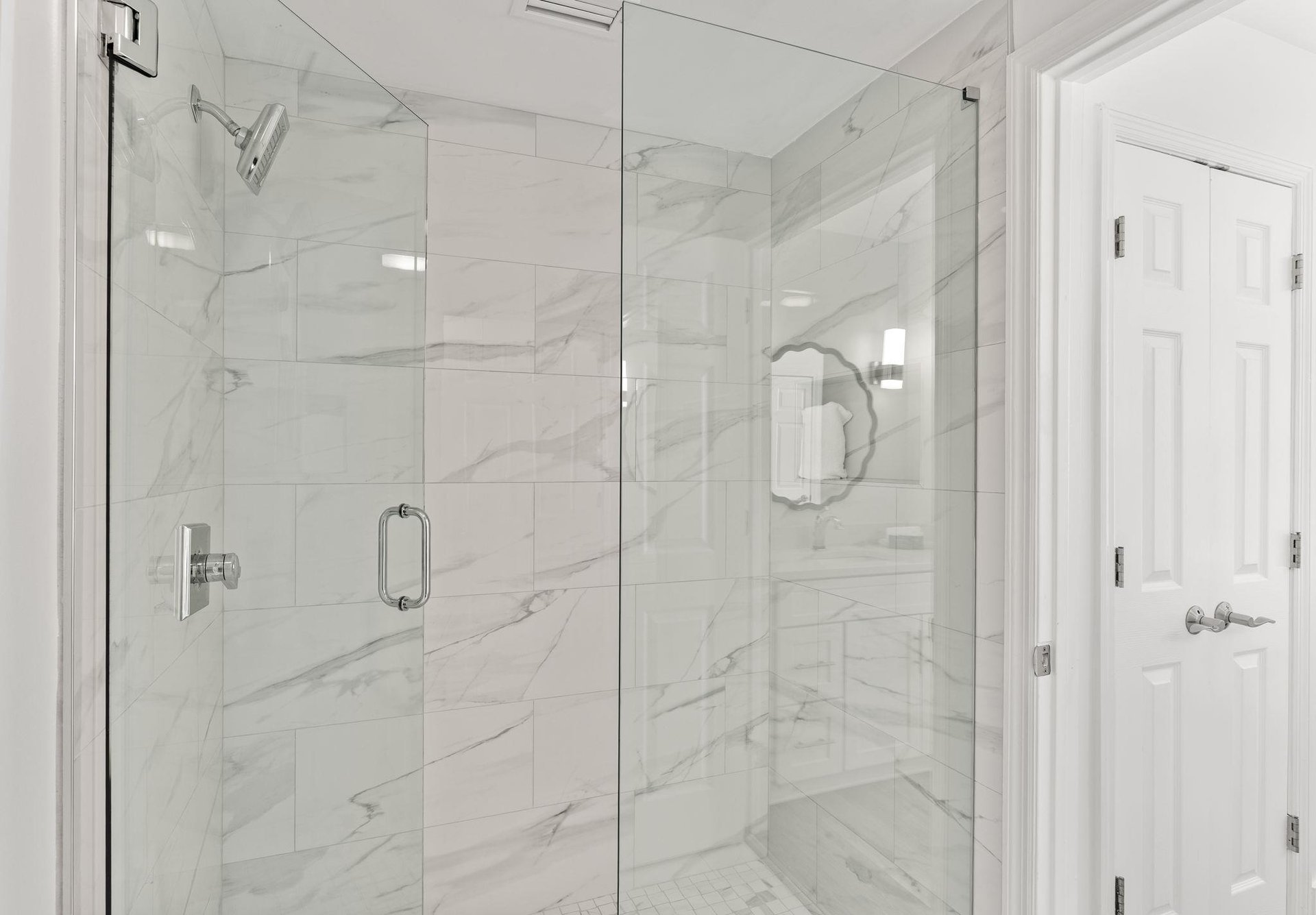 Step into your spalike marble shower where elegant veining creates a serene backdrop for your daily refresh.