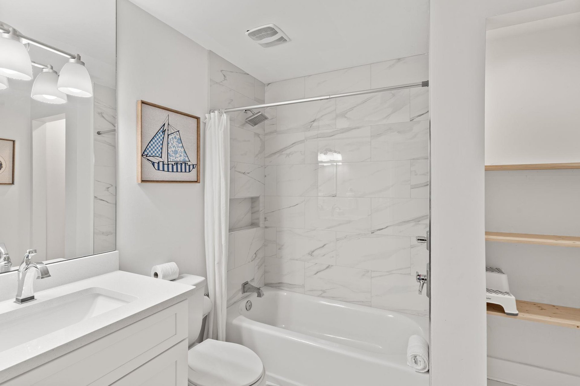 Relax in your pristine 2nd floor shared bathroom featuring elegant marblelook tiles, a soaking tub, and thoughtful nautical touches that create a spalike retreat.
