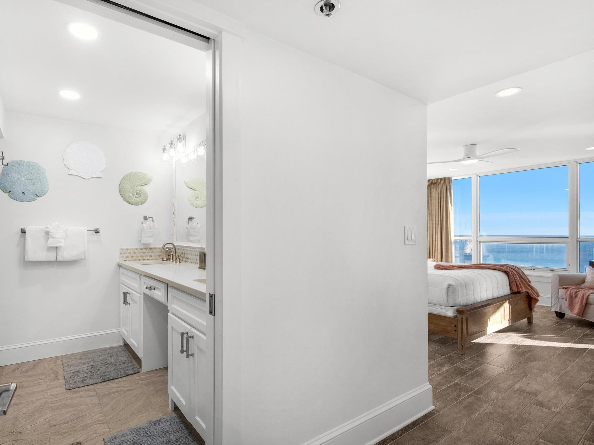 Spacious bedroom with stunning ocean views through floortoceiling windows, featuring your private ensuite bathroom.