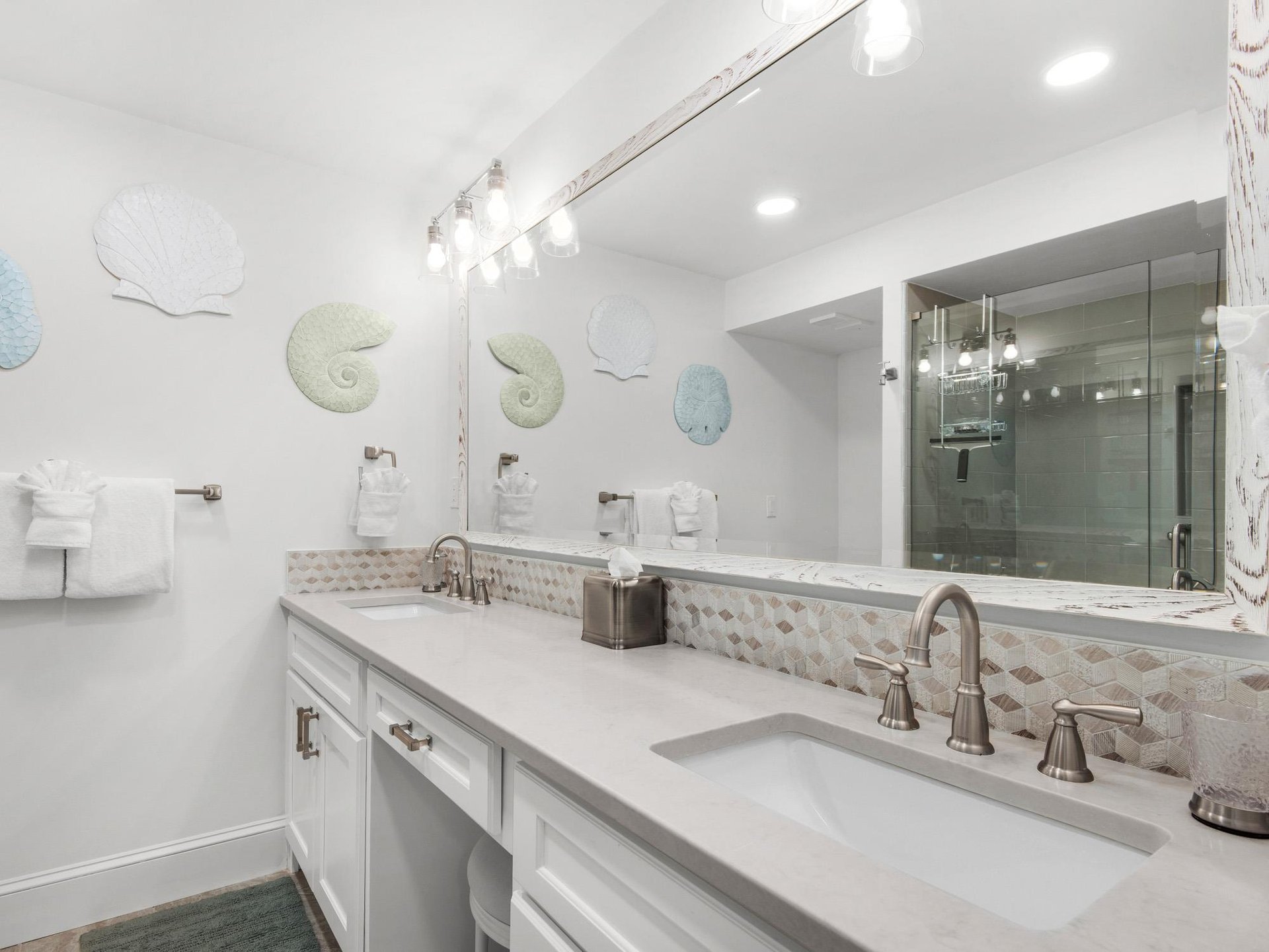 Pamper yourself in this elegant dualvanity bathroom featuring marble countertops, designer lighting, and a luxurious glassenclosed shower.