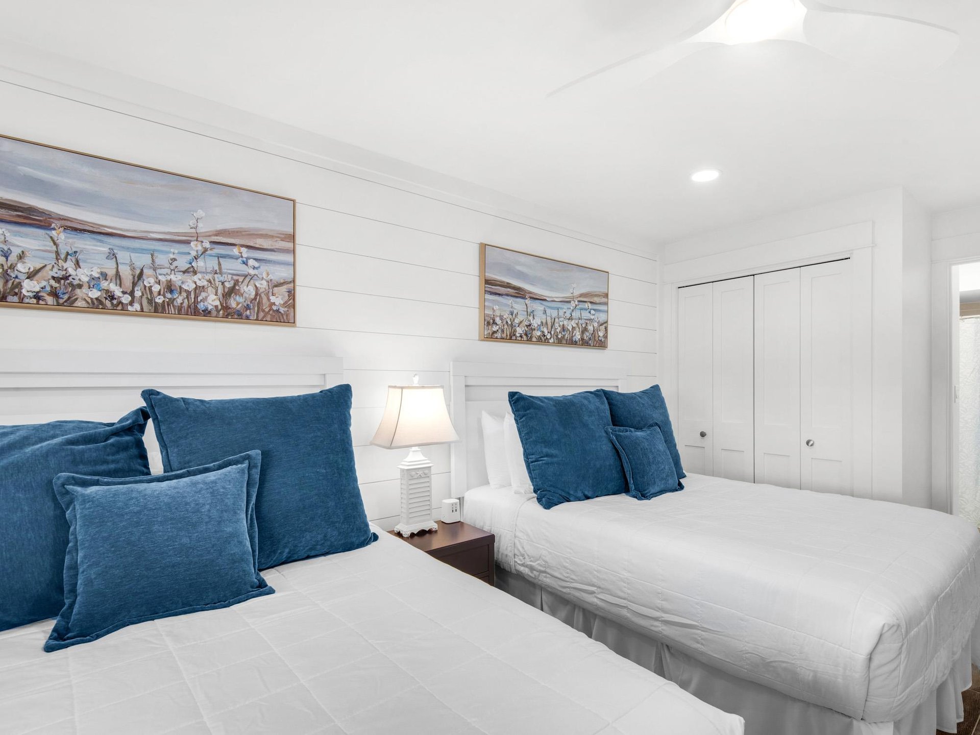 Drift off to sleep in this serene twin bedroom, where crisp white linens meet oceanblue accents and coastal artwork creates your peaceful seaside retreat.