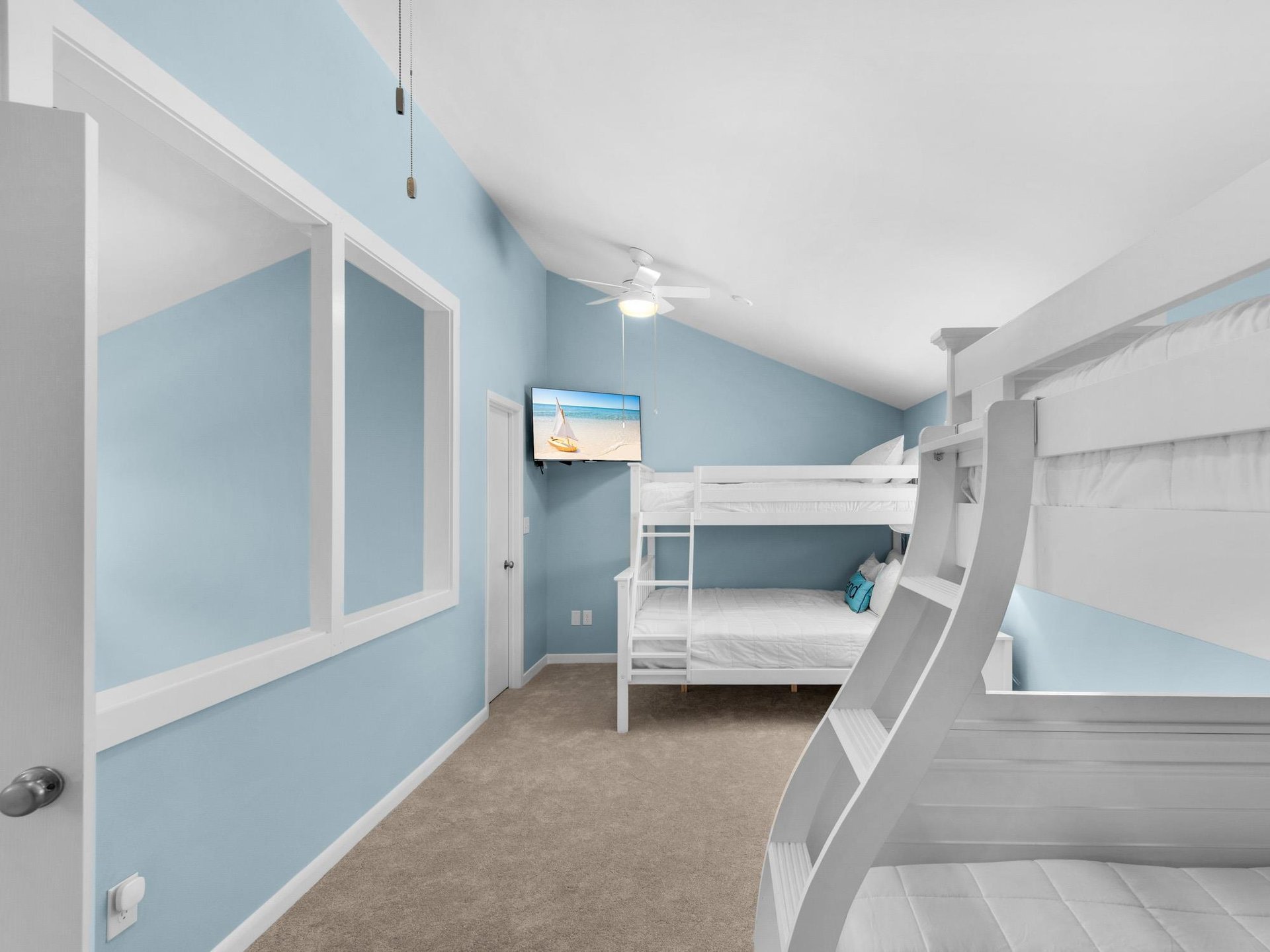 Your kids will love this cheerful bunk room with oceanblue walls and crisp white beds, complete with entertainment for cozy evenings.