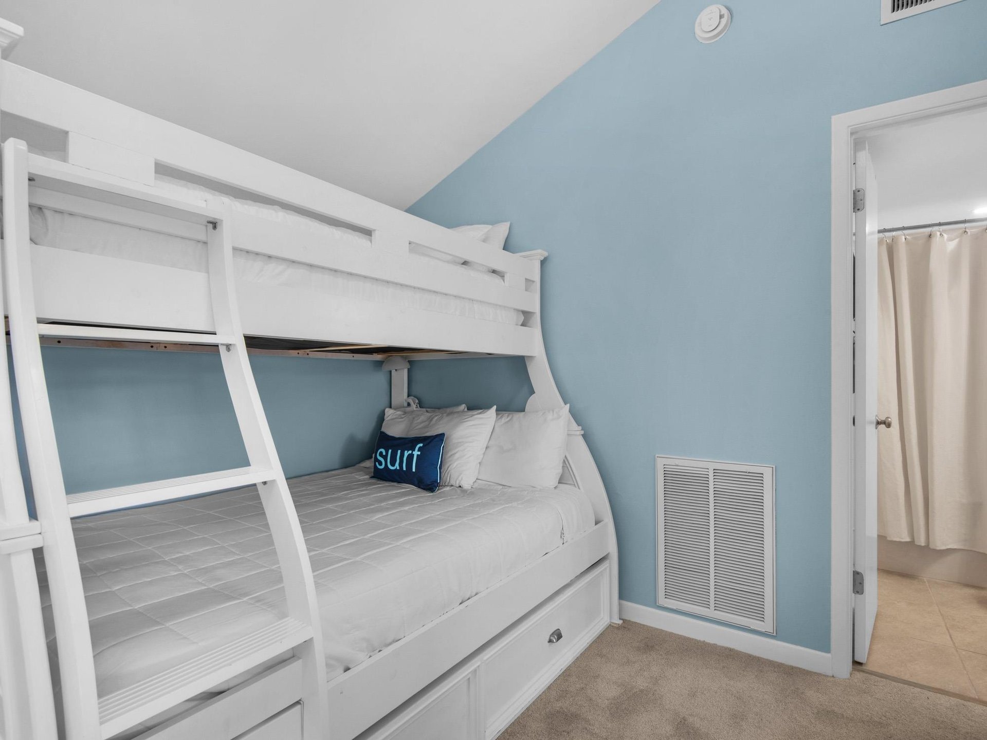 Cozy bunk room with crisp white linens and soothing blue walls creates your perfect beach retreat sleeping space.