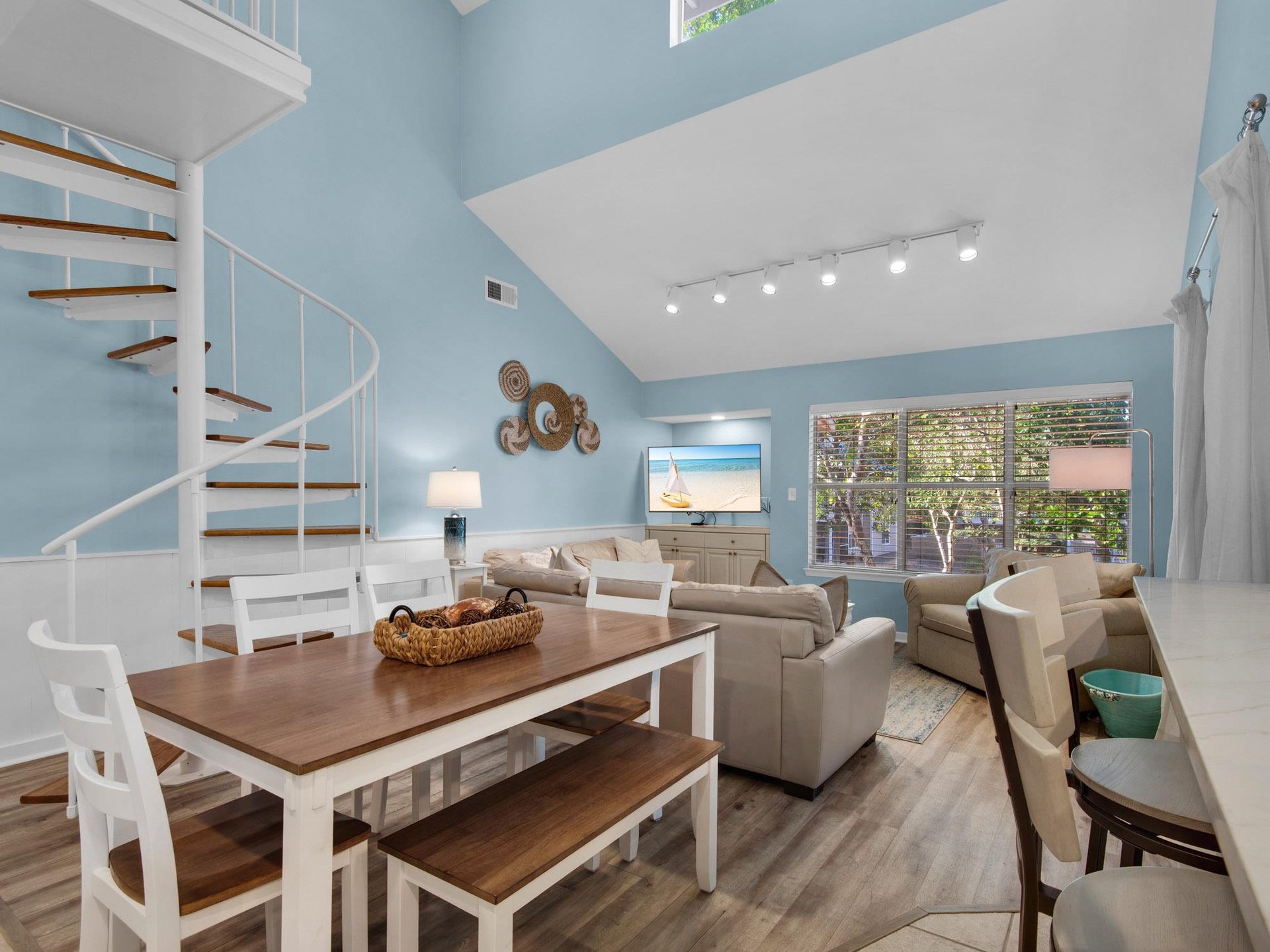 Unwind in your bright, openconcept space where coastal blue walls meet modern comfort. Your spiral staircase adds charm to this stylish retreat.
