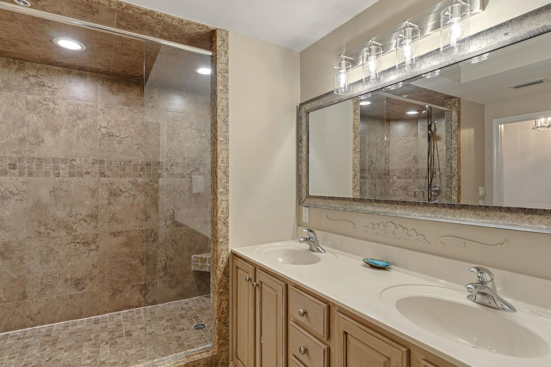 Bathroom 1 with dual sinks, granite counters, and spacious walkin shower with beautiful stone tile work awaits your relaxing retreat.