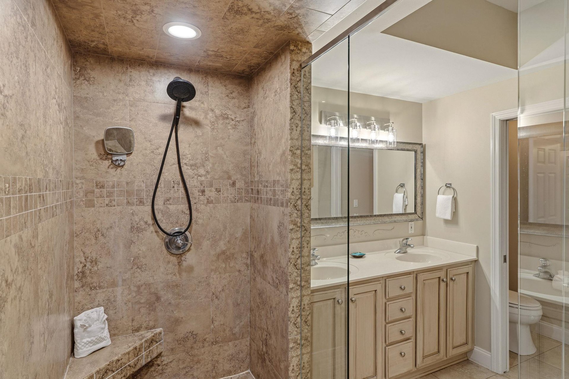 Bathroom 1 Unwind in your private spalike bathroom featuring a luxurious stone shower with bench and dual vanity space for getting ready.