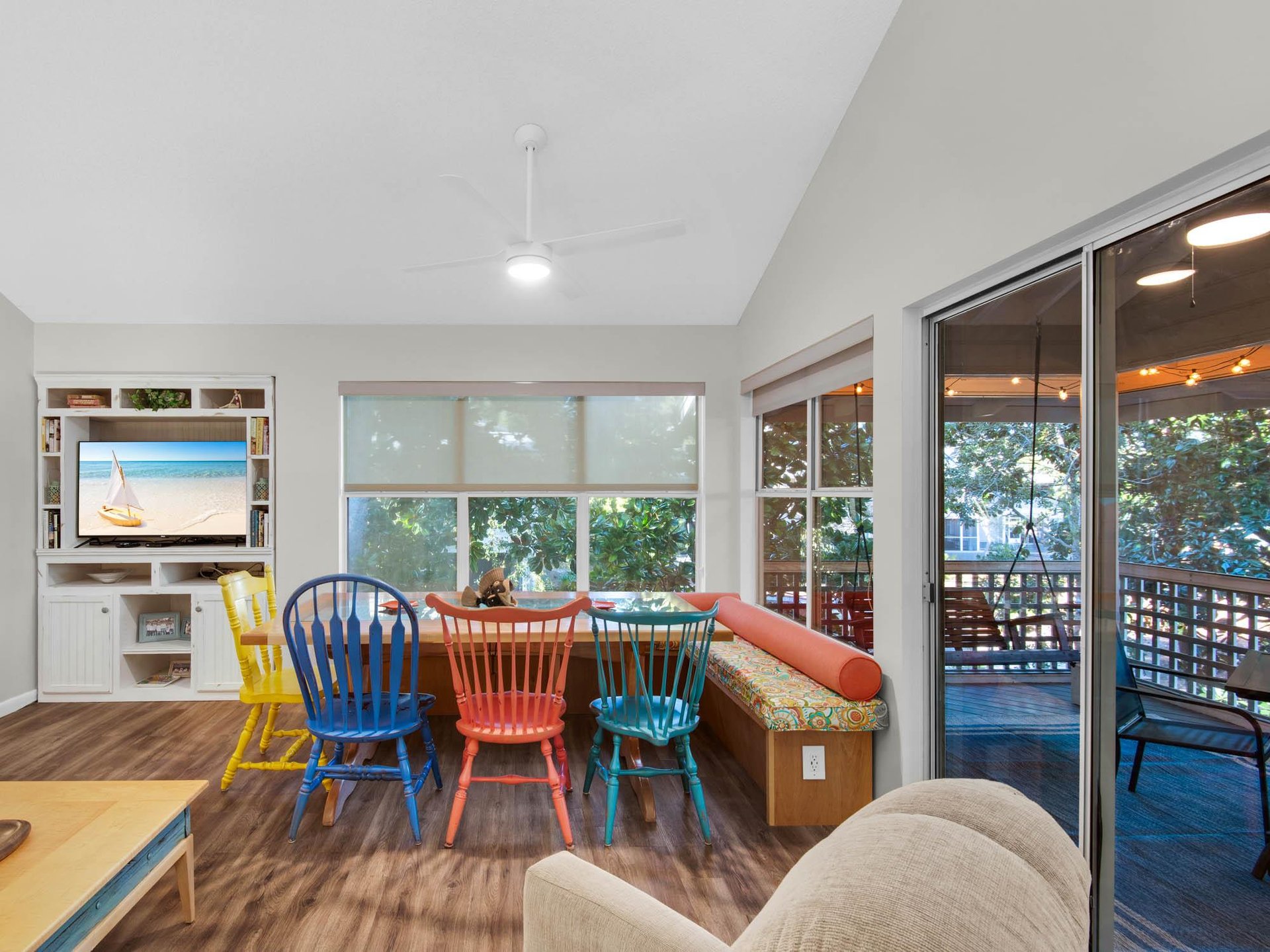 Gather around your cheerful dining table with colorful chairs, where morning coffee and evening conversations flow naturally in this bright, open space.