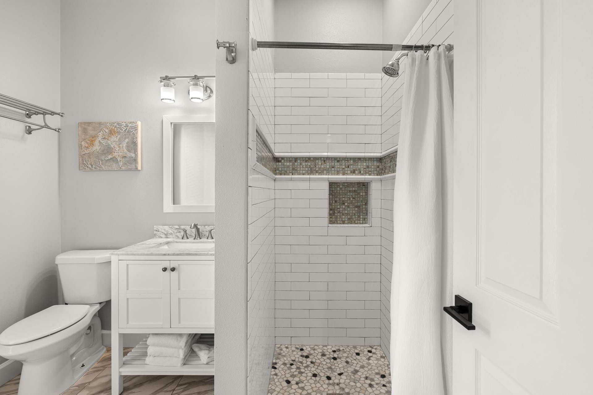 Step into the beautifully designed bathroom featuring a luxurious tiled shower with rainfall head and elegant marbletopped vanity for your comfort