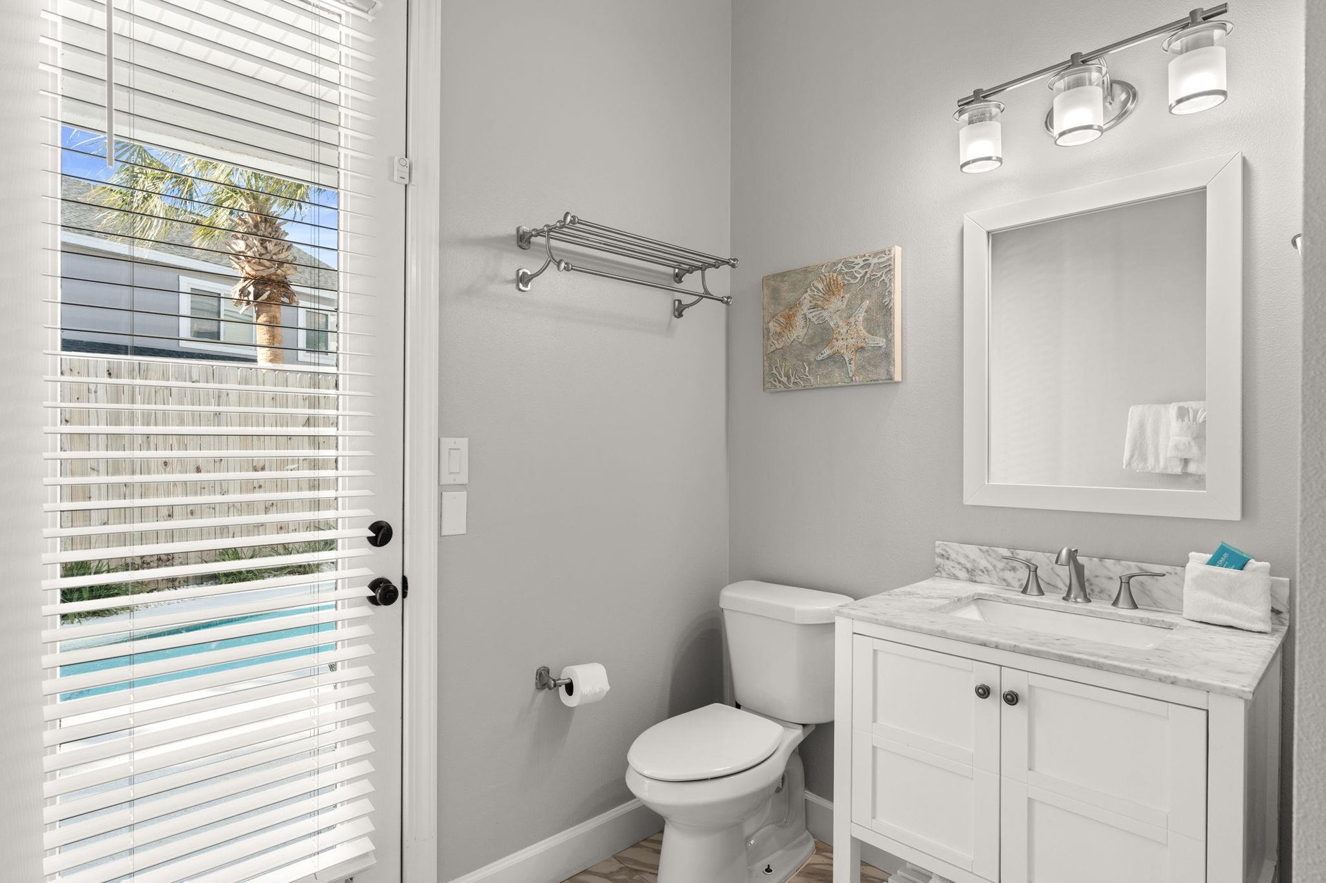 The pristine guest bathroom features marble countertops, modern fixtures, and plenty of natural light to refresh yourself during your stay.