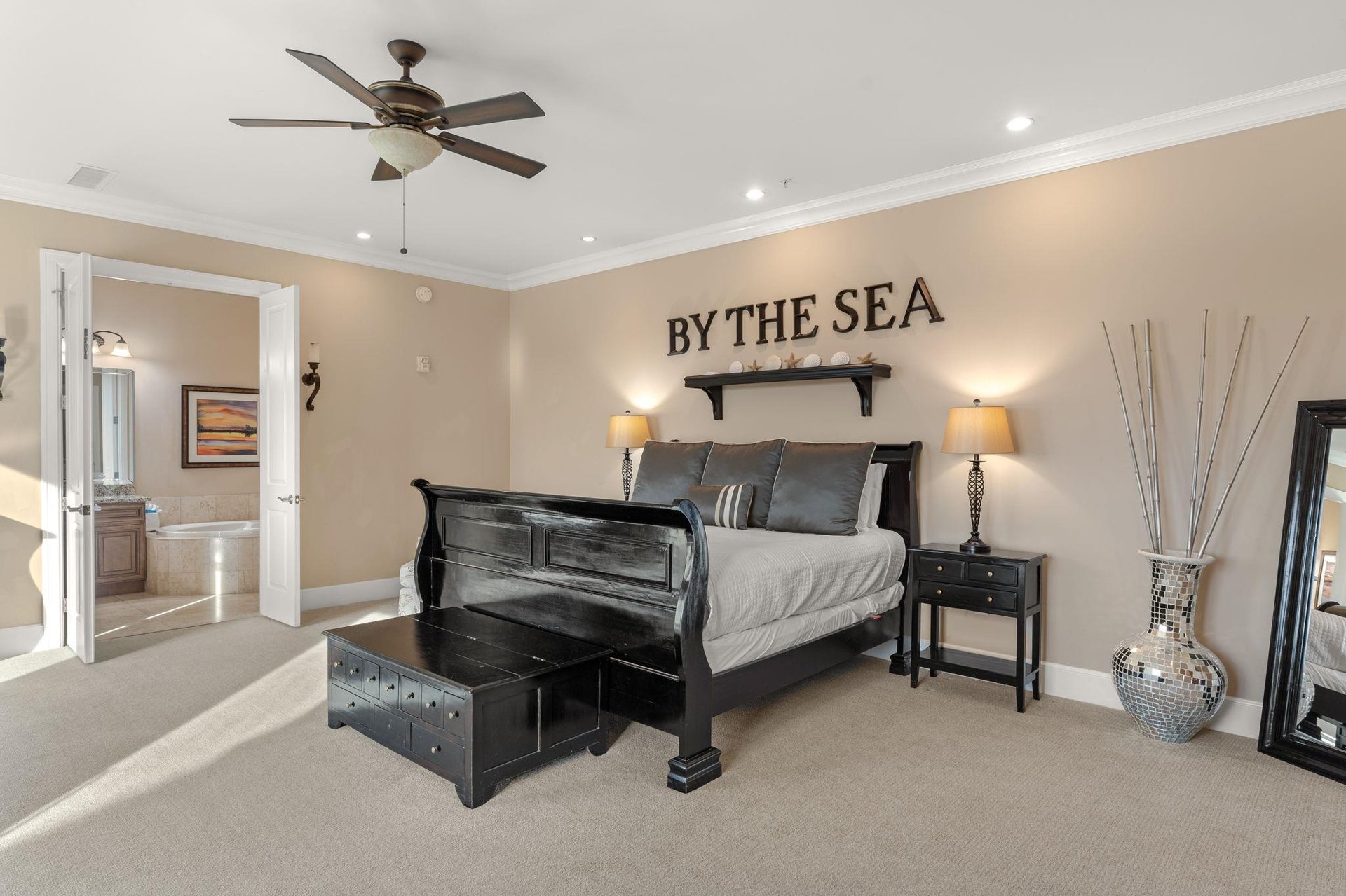 Your coastal retreat awaits with a plush king bed, gentle ceiling fan, and nautical touches that whisper seaside dreams.