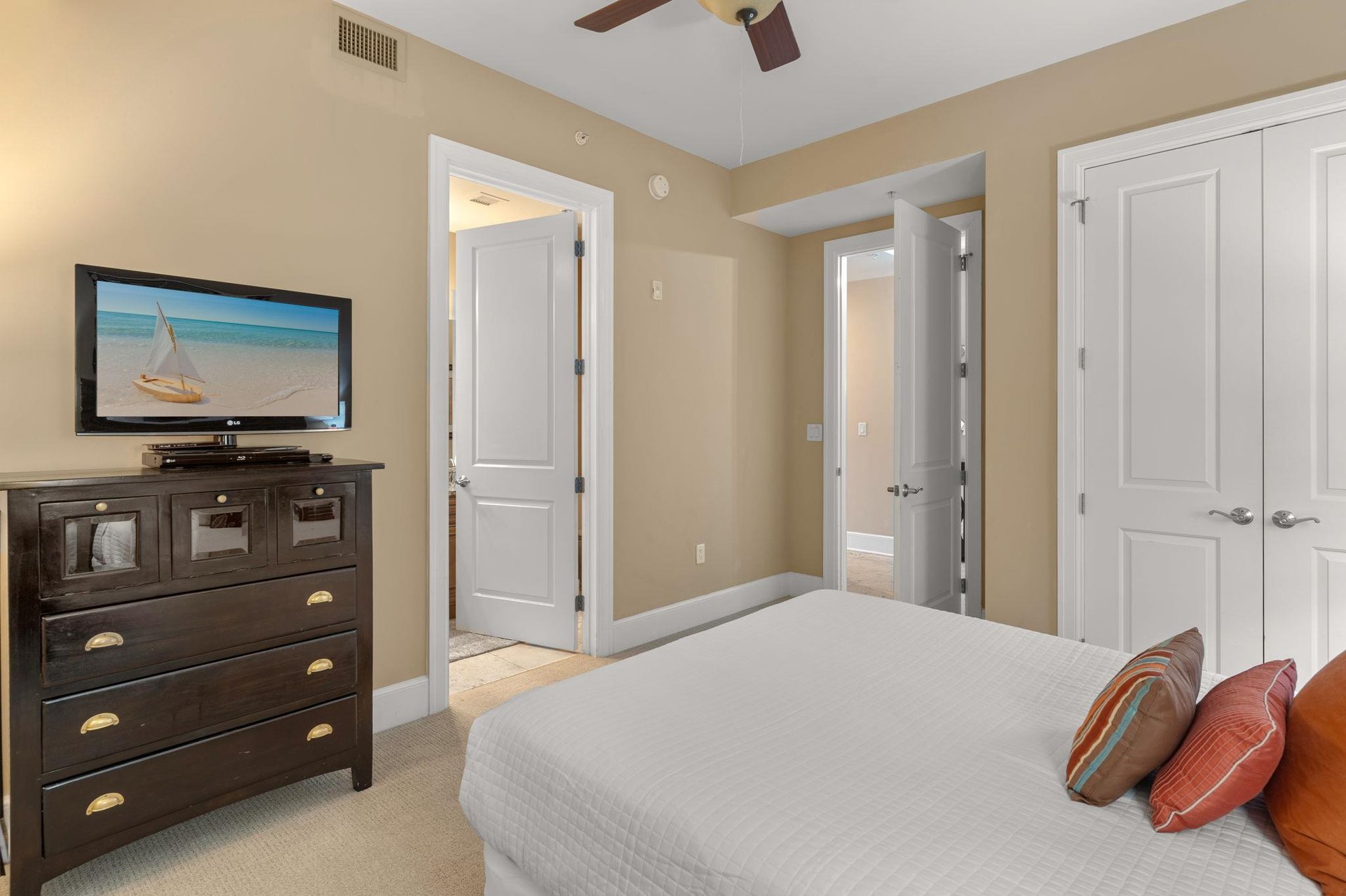 Unwind in your peaceful bedroom with oceaninspired decor, ceiling fan, and entertainment center for ultimate relaxation.