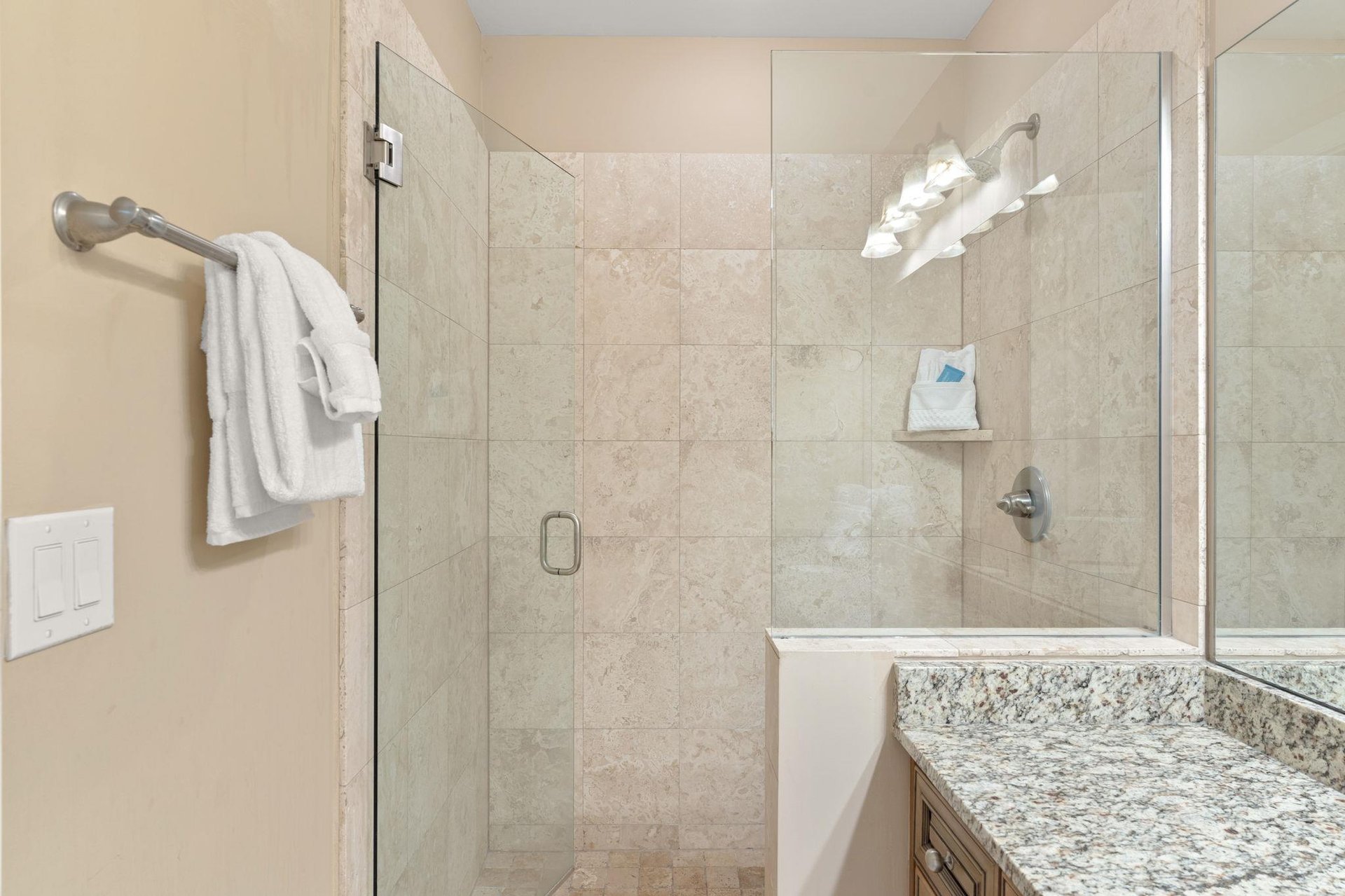 Step into your elegant marble bathroom featuring a spacious glassenclosed shower with premium fixtures and plush towels waiting for you.