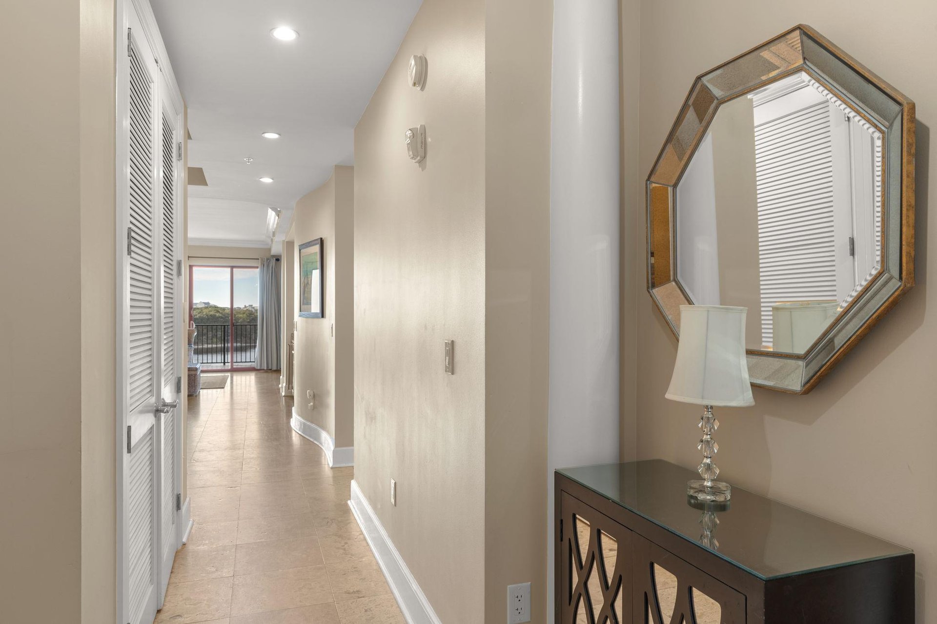 Step into your elegant hallway where natural light floods through, leading you toward your private balcony retreat.