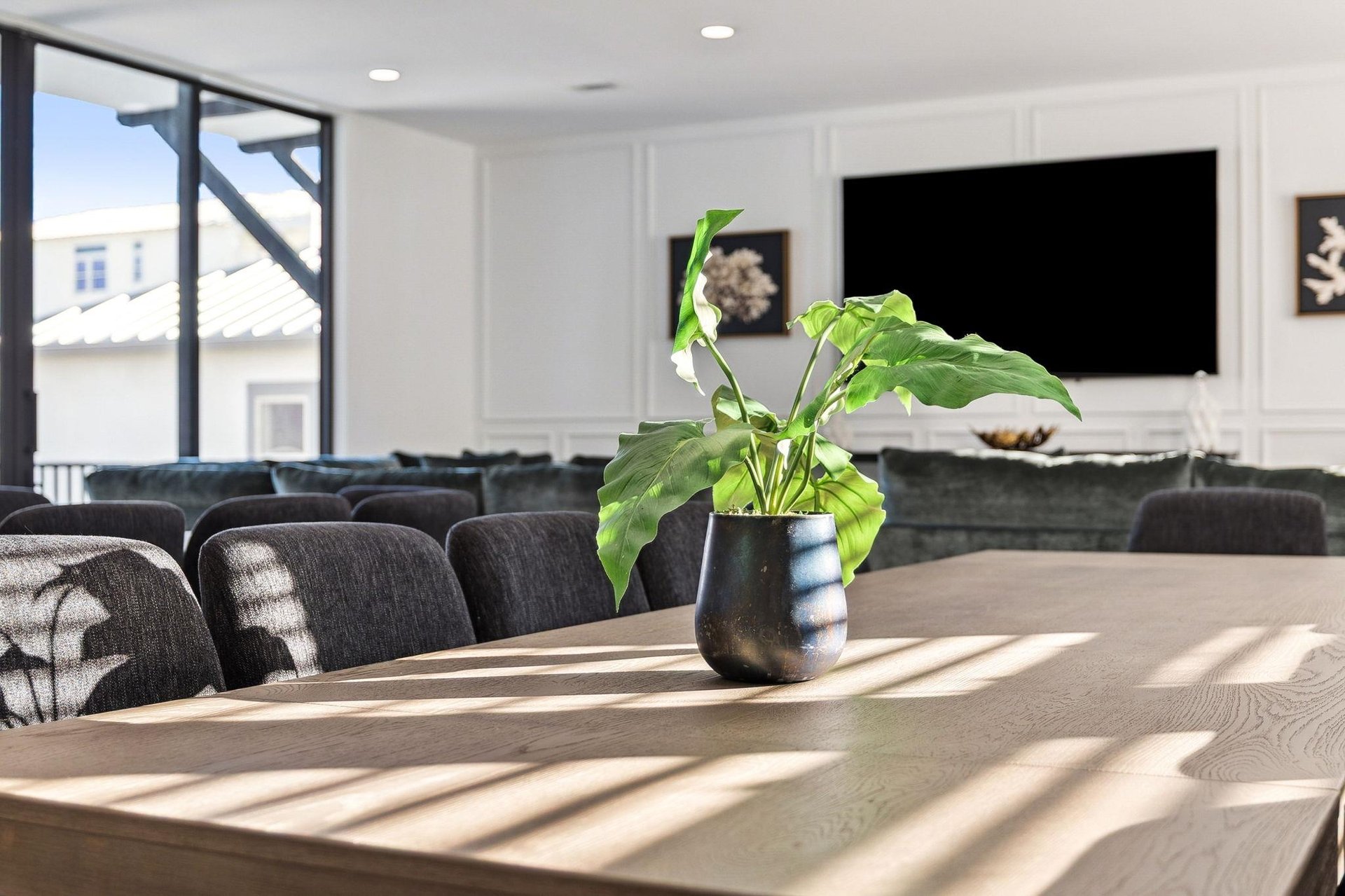 Gather around this beautiful dining table where sunlight streams through large windows, creating the perfect space for meals and conversations.