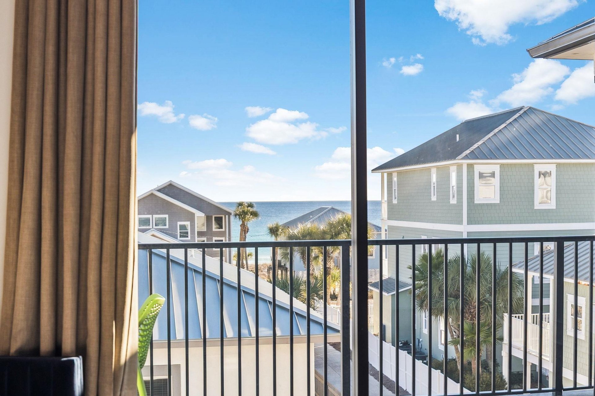 Wake up to stunning ocean views framed by coastal homes and swaying palms from your private balcony perch.