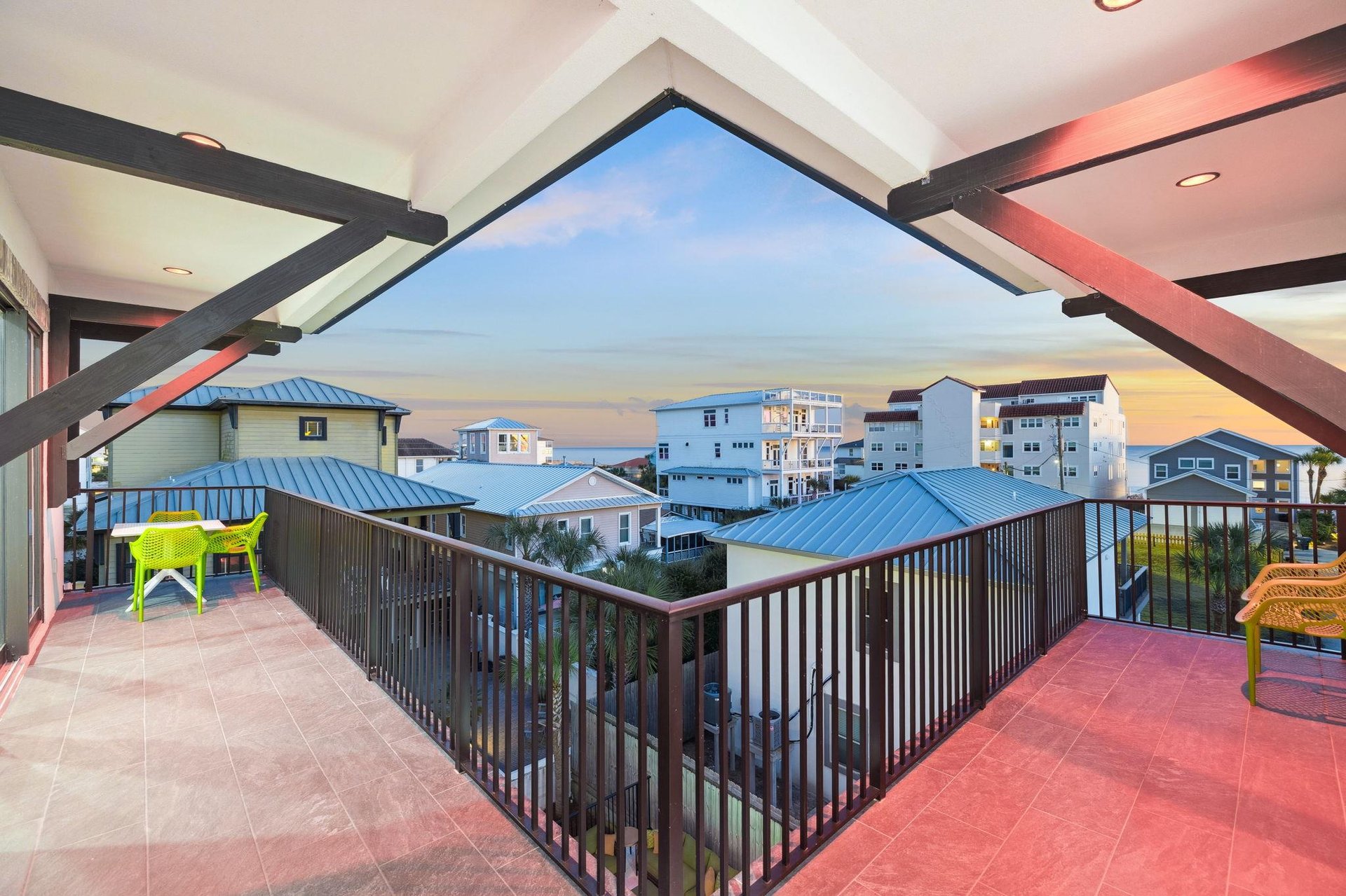 Spacious 3rd floor balcony overlooks colorful beach town buildings under evening sky.