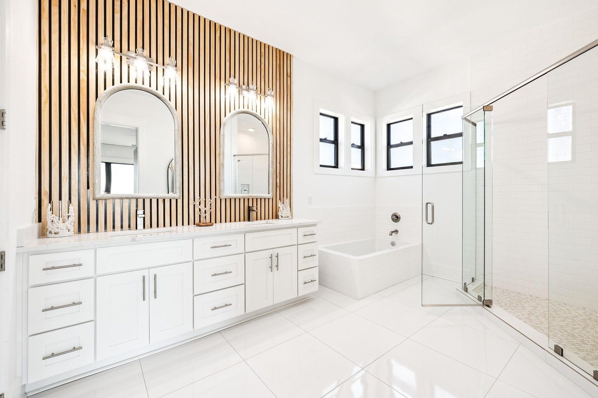 Indulge in your private spalike retreat with elegant wood slat accents, soaking tub, and spacious glass shower for ultimate relaxation.