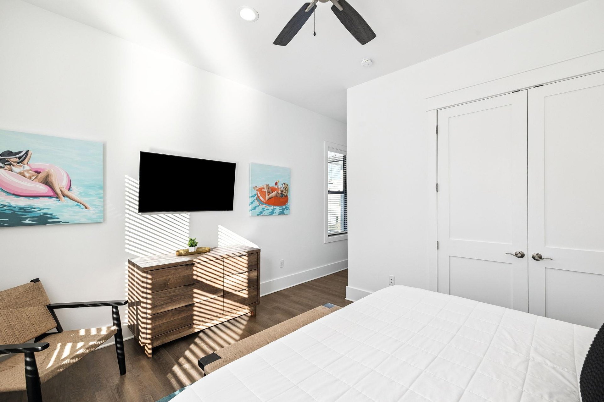 Drift off to sleep in your bright, airy bedroom where morning sun creates beautiful patterns across crisp linens and playful artwork sets a relaxed tone.