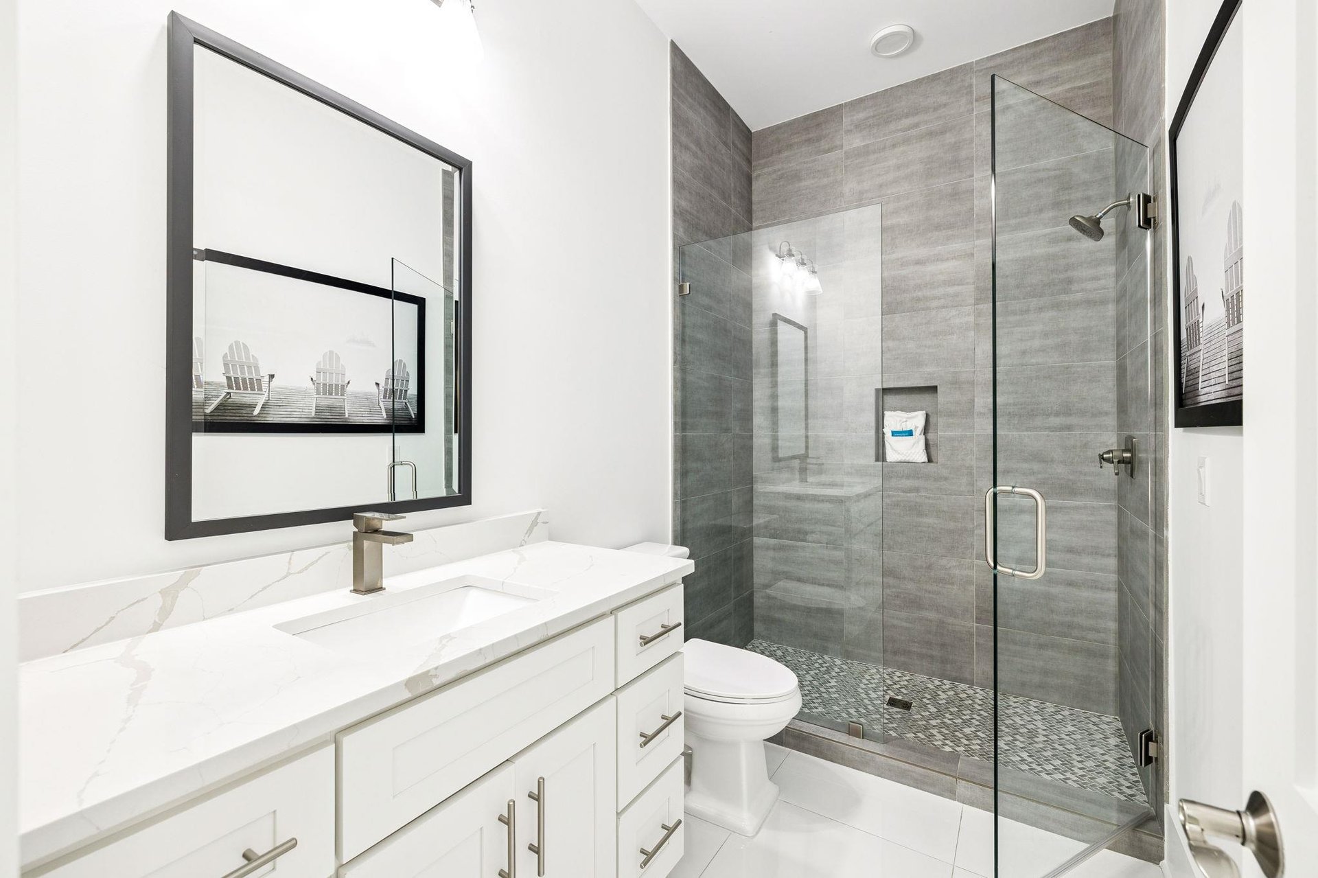 Refresh in your elegant marble bathroom with a spacious glassenclosed shower and pristine white vanity.