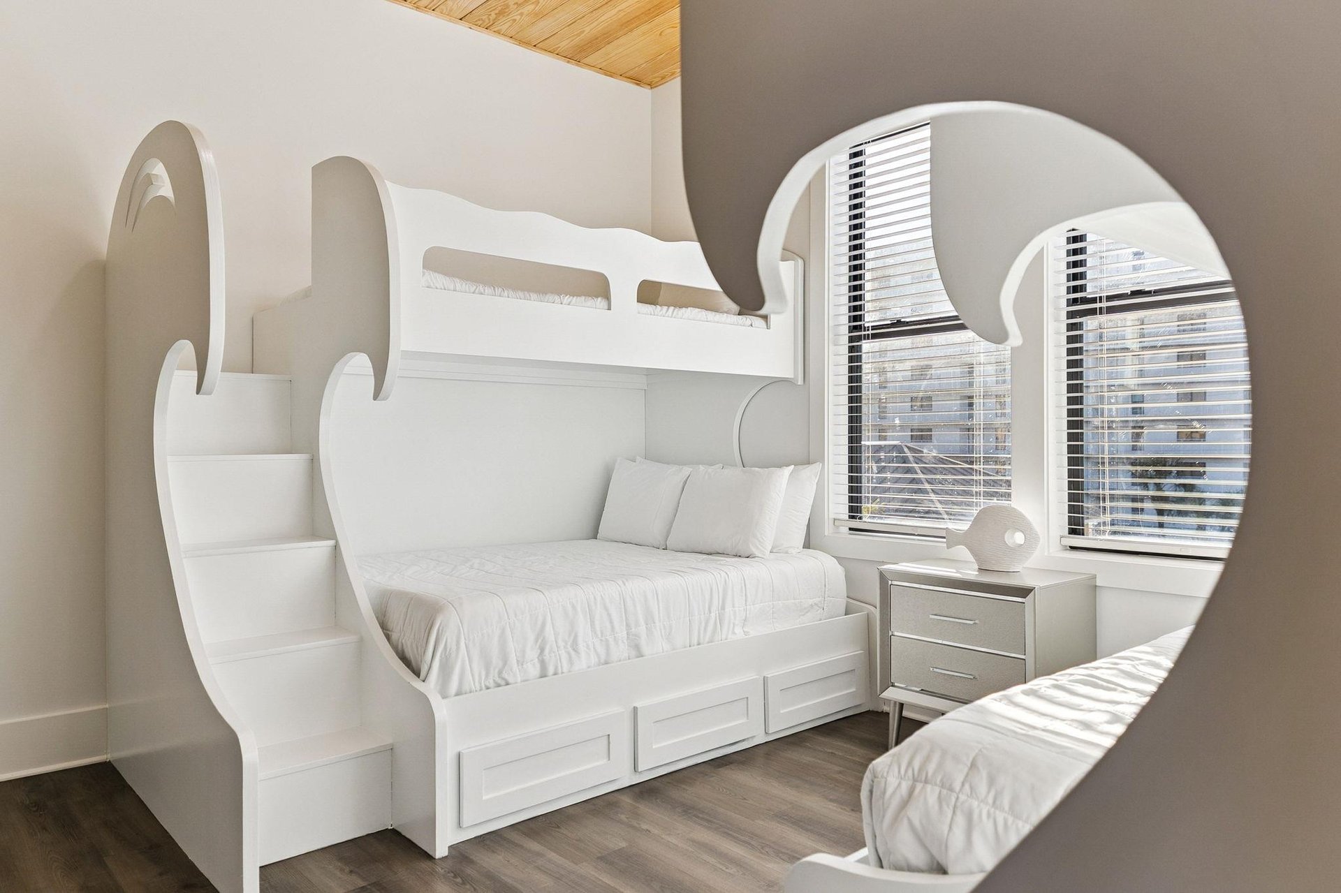 Your unique room features stylish white bunk beds with builtin storage and steps, perfectly designed for comfort and fun.