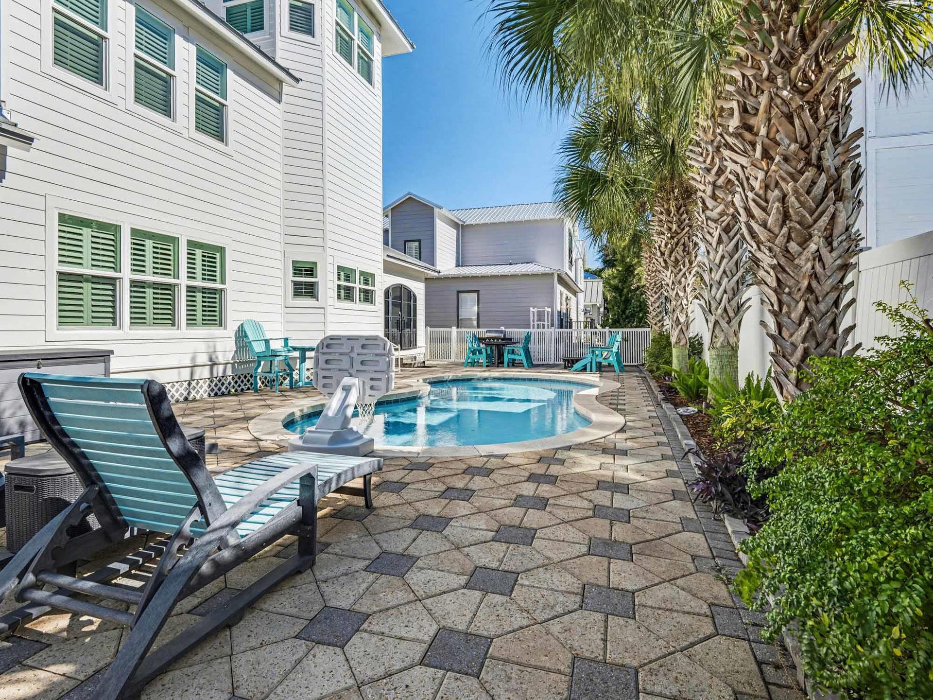 Your private pool oasis awaits with comfortable loungers and tropical palms, perfect for sunny afternoon relaxation.