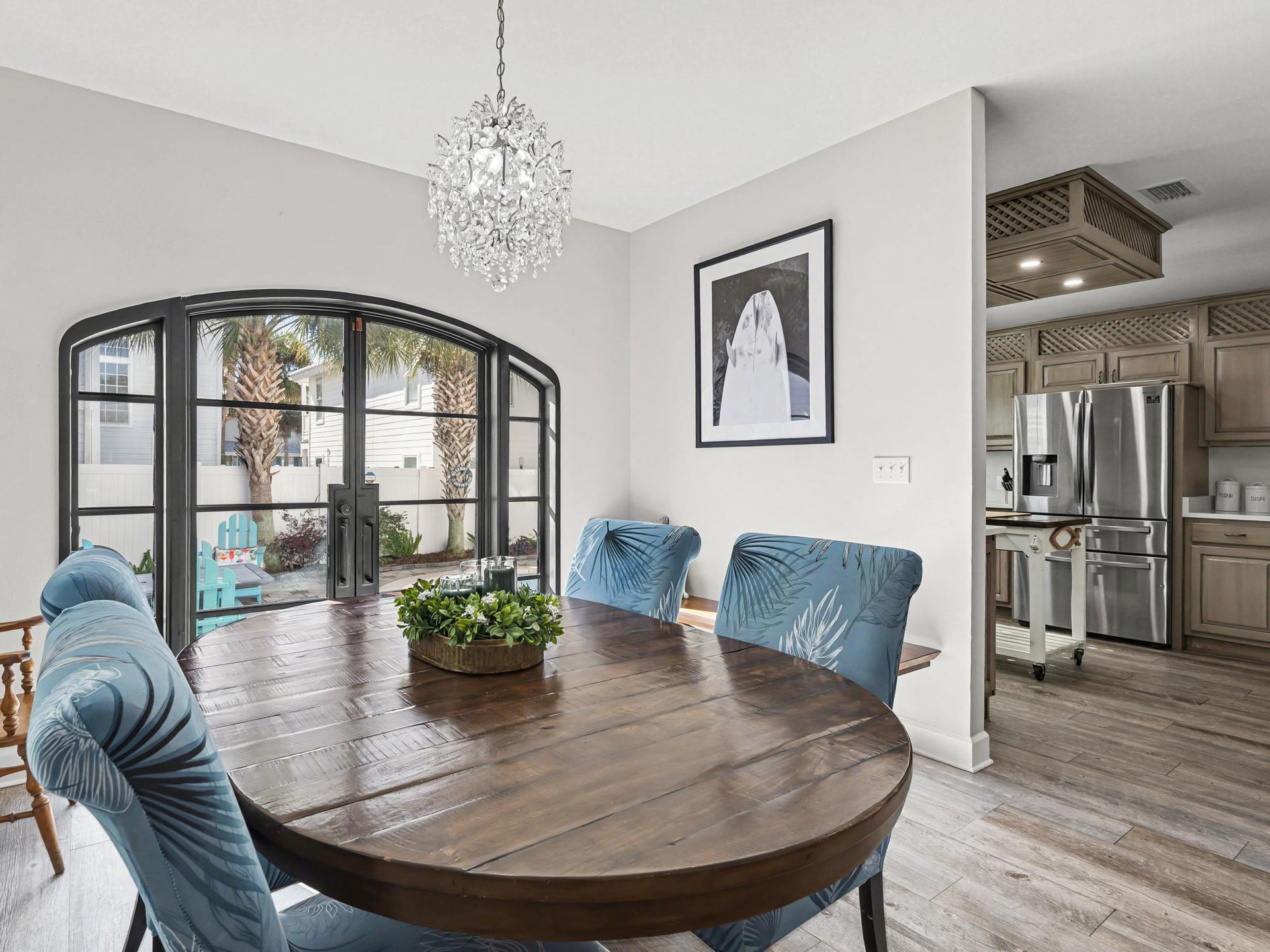 Youll love gathering around this elegant dining table beneath the sparkling chandelier, with natural light streaming through beautiful French doors.