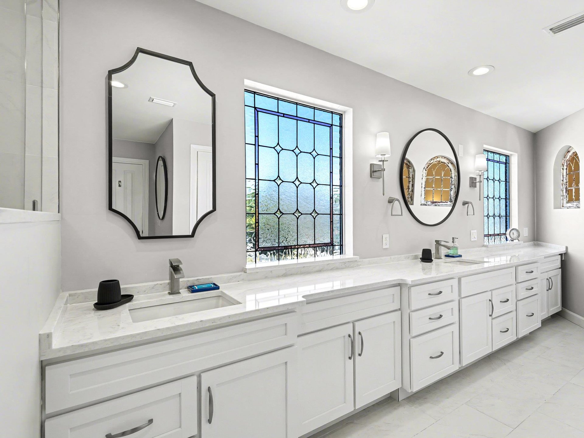 Pamper yourself in this stunning bathroom with dual vanities, marble countertops, and elegant mirrors perfect for your morning routine.