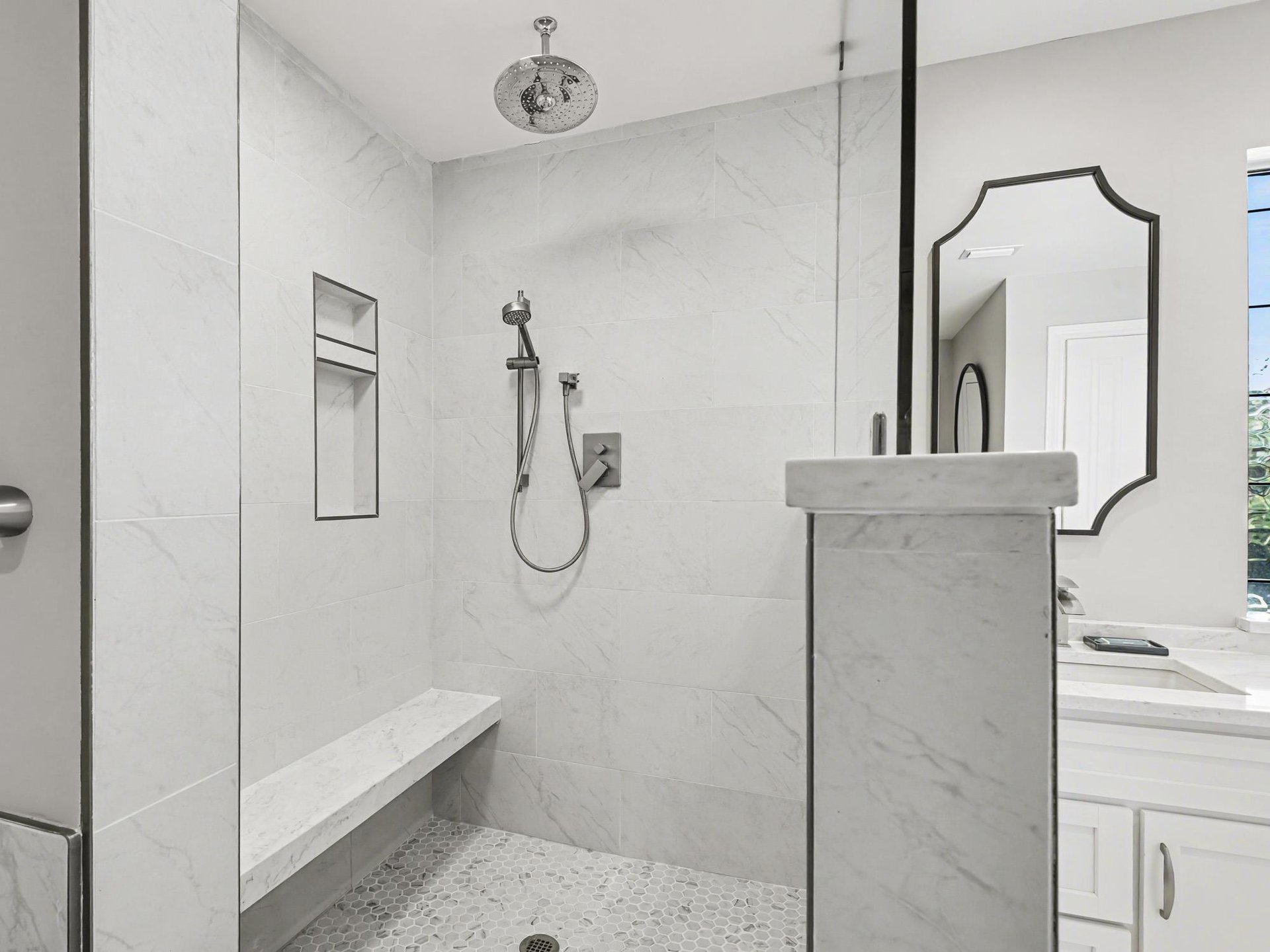 Step into your luxurious walkin shower featuring elegant marble walls, rainfall showerhead, and builtin bench for pure relaxation.
