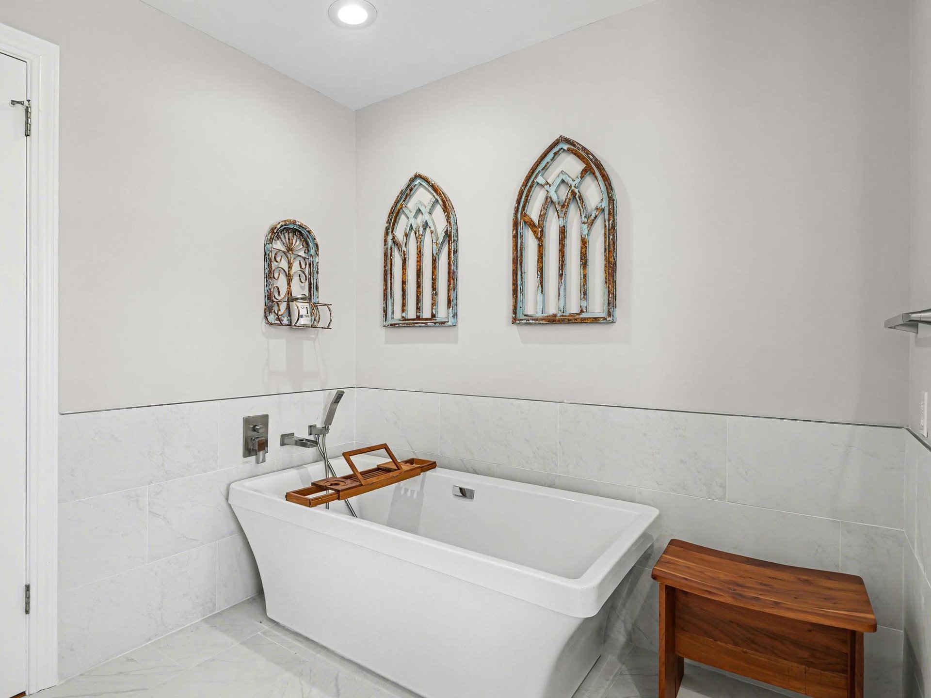 Unwind in your elegant soaking tub surrounded by cathedralstyle mirrors and warm wood accents for the perfect spalike retreat.